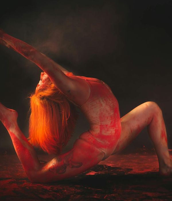 Silhouette of a person in a yoga pose against a vibrant, energetic background.